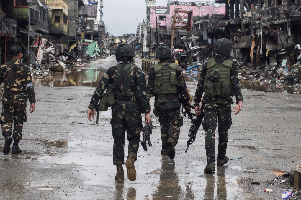 Government troops pass destroyed buildings and houses in Marawi city. Photo: Reuters