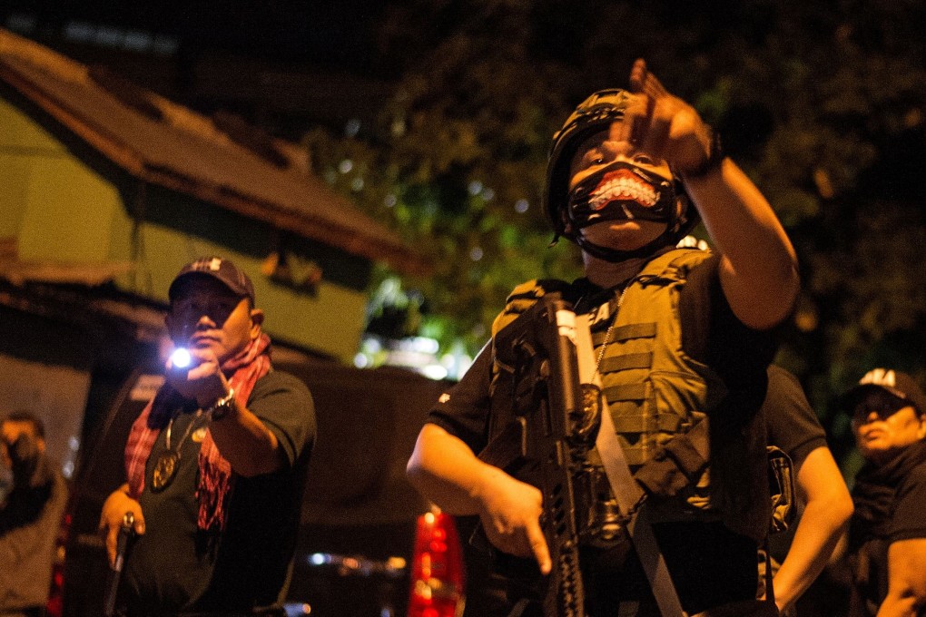 Philippine Drug Enforcement Agency agents and police secure part of a street as they search a house looking for a drug dealer during a raid in Maharlika village, south of Manila, on February 28, 2018. Photo: AFP