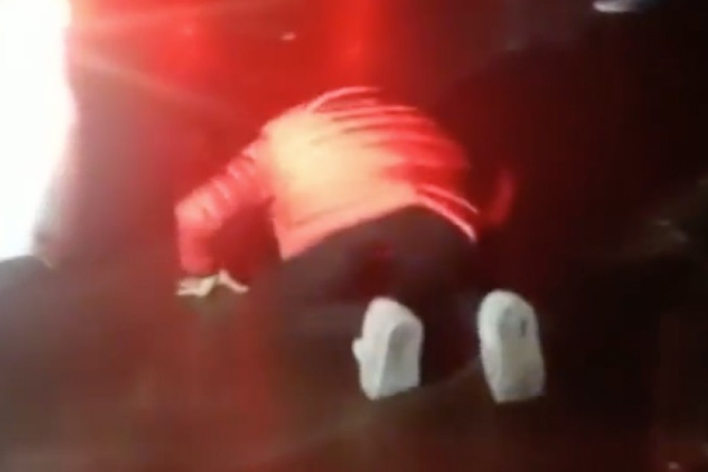 A woman gets on her hands and knees to plead with motorists to vacate an emergency lane so the ambulance carrying her injured son can get to hospital in Luan, Anhui province. Photo: Pear Video