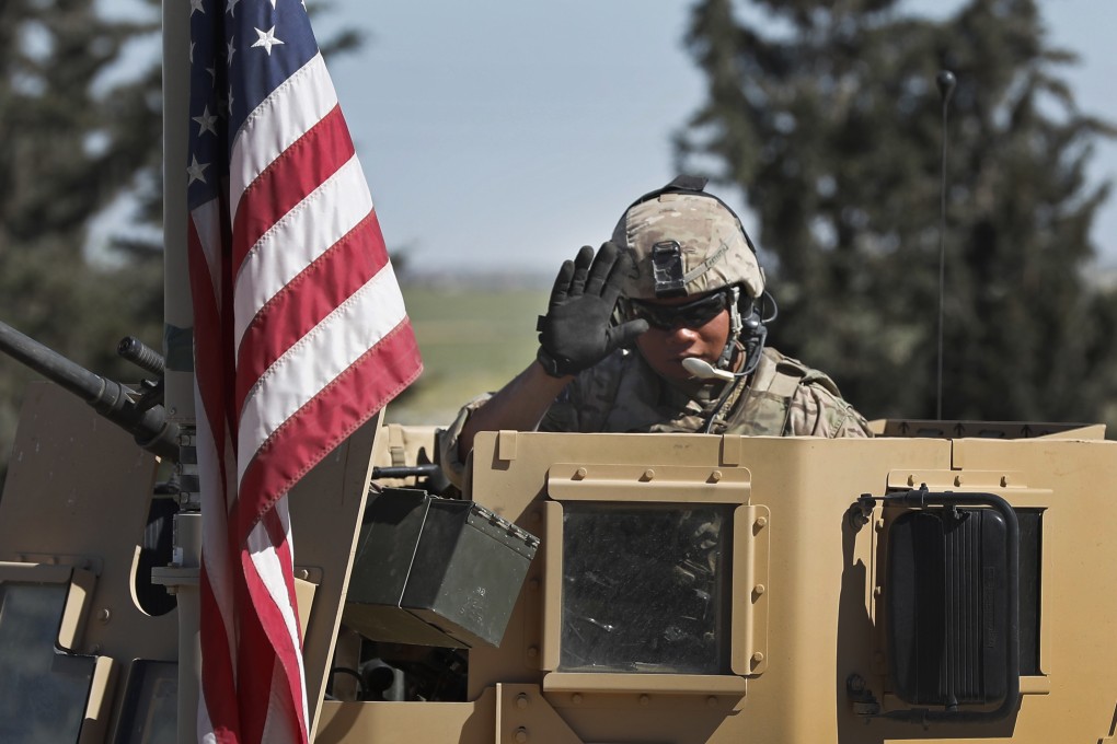 A US soldier waves from an armoured vehicle in Manbij, north Syria in April 2018. Photo: AP