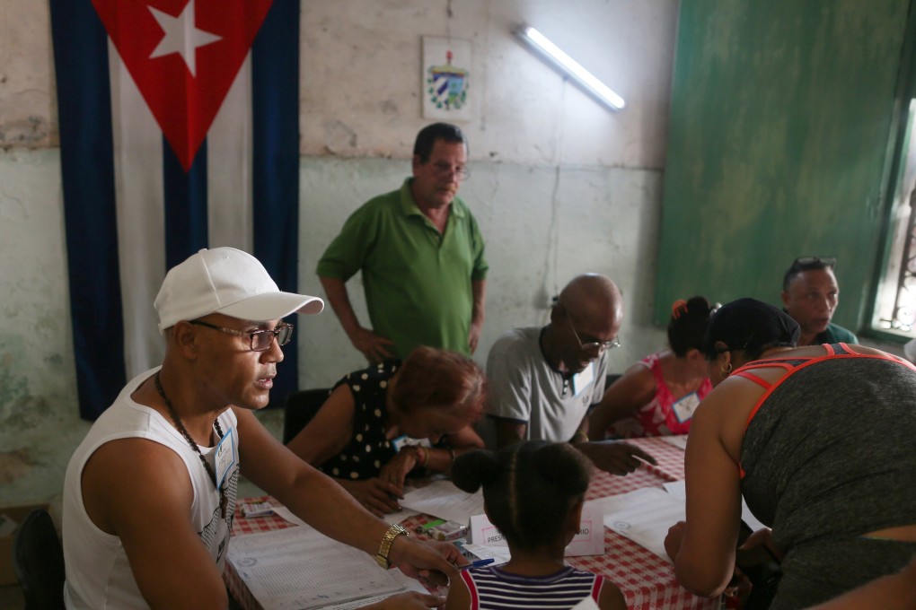 Election officials check the documents of a voter at a polling station during a constitutional referendum in Havana, Cuba. Photo: Reuters
