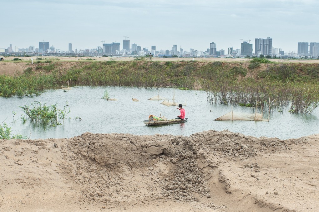 A young man trying to fish in Boeung Tompun next to a recent sand filled site in Phnom Penh. Photo: Enric Catala