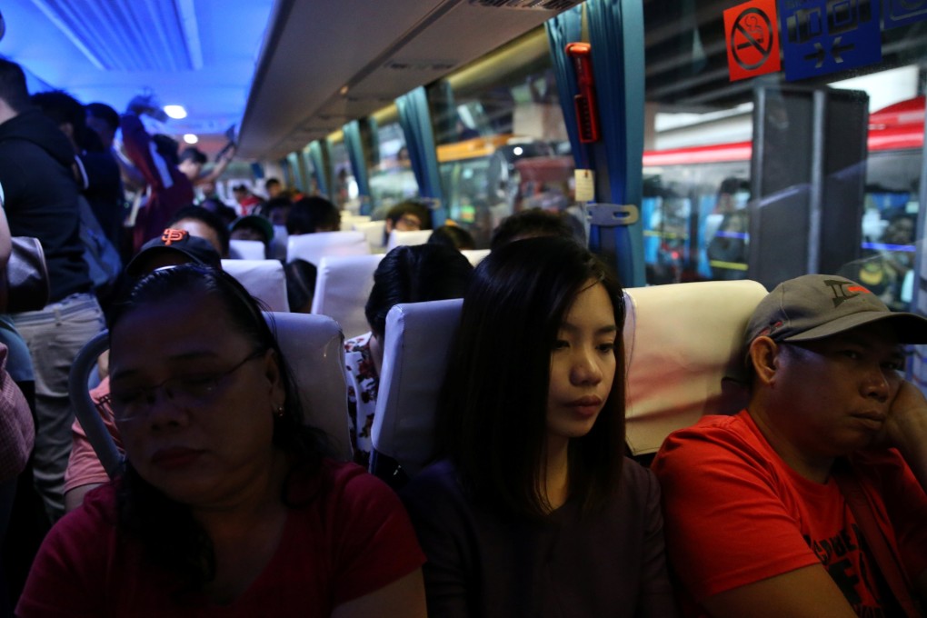 Janice Sarad, 22, who works for a bank, rides a crowded bus going to work in Cubao, Quezon City. Photo: Reuters