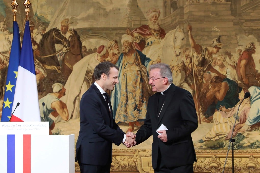 French President Emannuel Macron (L) shakes hands with Apostolic Nuncio to France Luigi Ventura during his New Year wishes to the diplomatic corps at the Elysee Palace in Paris. Photo: AFP