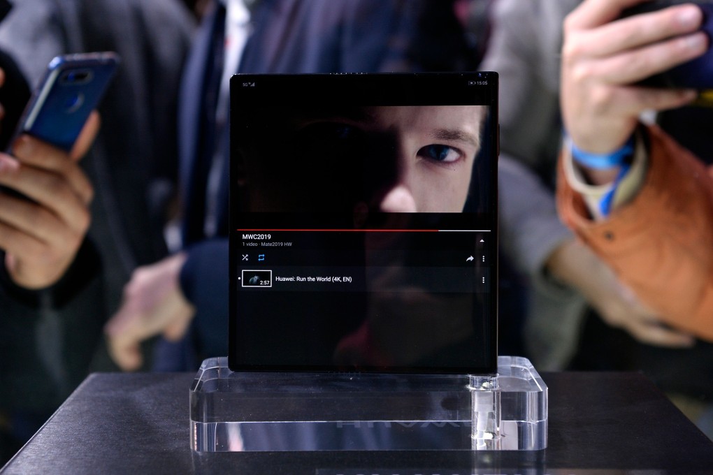 Visitors take photographs of Huawei’s new foldable 5G smartphone Mate X at the Mobile World Congress on February 24 in Barcelona. Photo: AFP