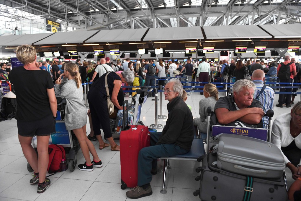Stranded passengers wait at the check-in area at the Suvarnabhumi International Airport in Bangkok. Photo: AFP