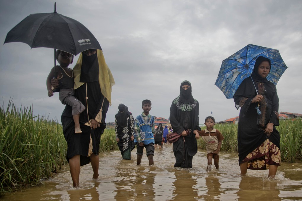 Rohingya Muslims, who crossed over from Myanmar into Bangladesh, wade towards the Jamtoli refugee camp in Ukhiya. Photo: AP