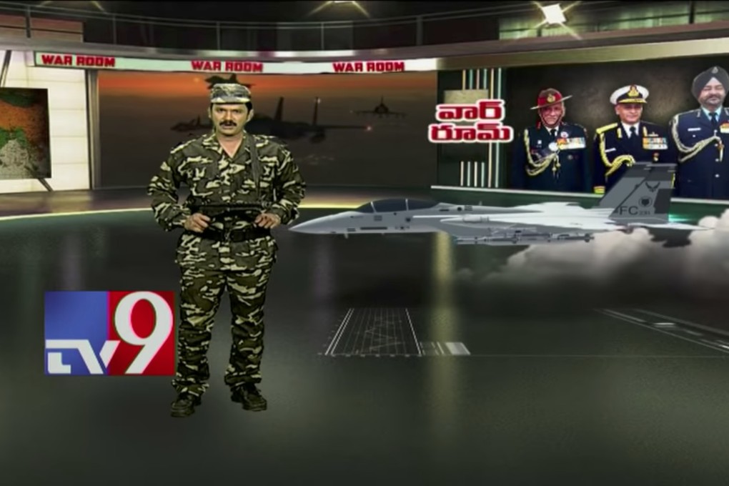 A screengrab of a TV9 anchorman wearing combat fatigues, holding a replica gun. Source: YouTube