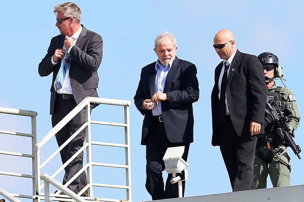 Brazilian former President Luiz Inacio Lula da Silva (2-L) is escorted back to his prison after attending the funeral of this grandson Arthur Araujo Lula da Silva, in Curitiba, Brazil. Photo: EPA-EFE