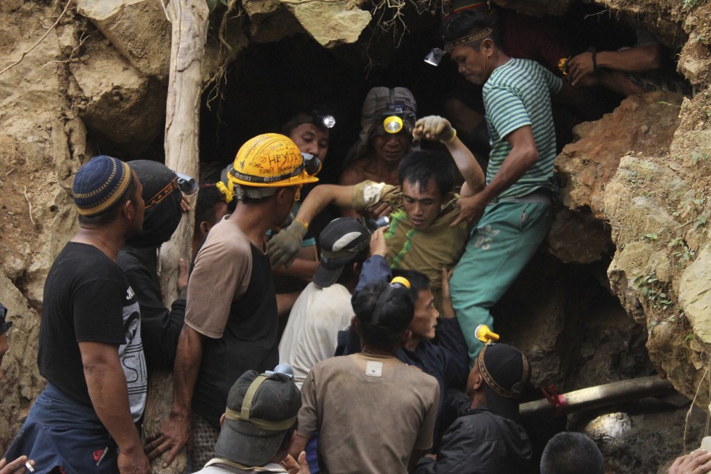Rescuers carry a survivor from inside a collapsed mine in north Sulawesi. Photo: AP