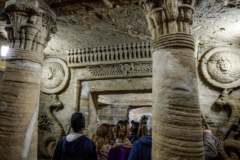 Visitors tour through the catacombs of Kom al-Shoqafa (Mound of Shards), dating to the Roman period (1st-4th centuries AD) in the centre of the Egyptian Mediterranean coastal city of Alexandria on March 3, 2019, during the inauguration of a project to drain groundwater from the archaeological site. Photo: AFP