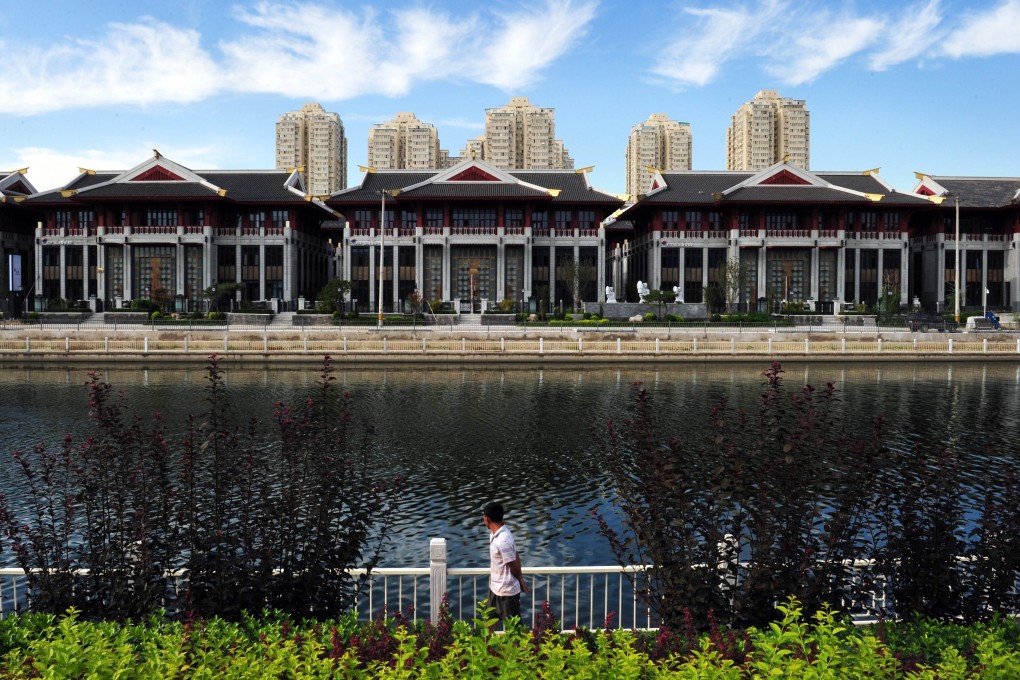 Expensive lakeside villas stand in front of public housing in the Chaoyang district of Beijing. Luxury property sales have been declining in China. Photo: AFP