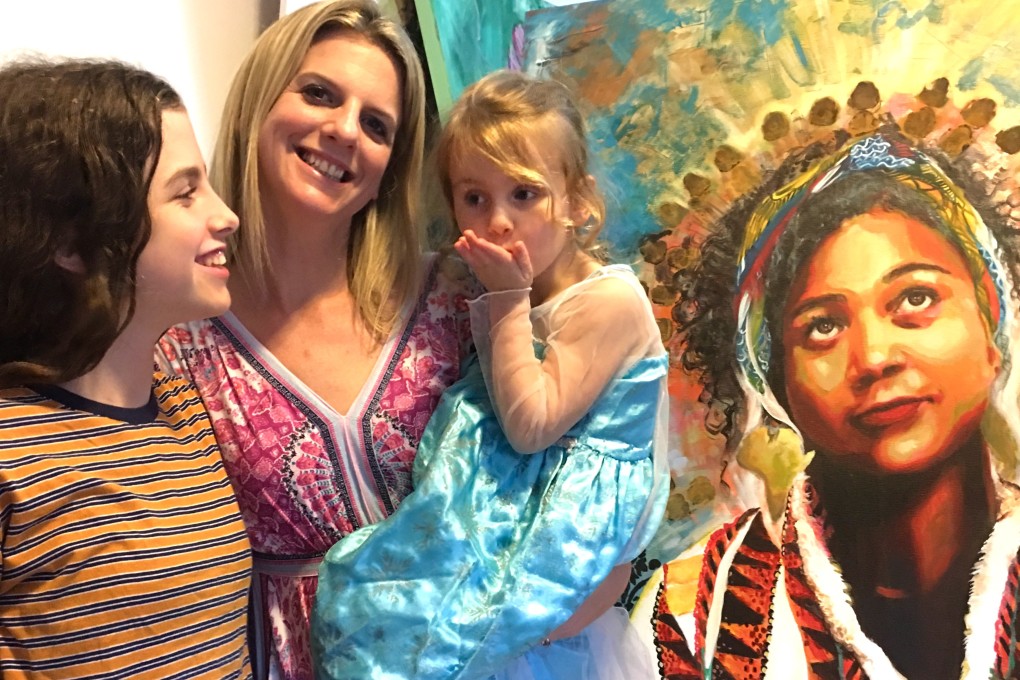 Kate Sparrow and daughters Matilda (left) and Violet in front of I am Leto, a portrait of the artist Nina Gadd. Picture: Kylie Knott