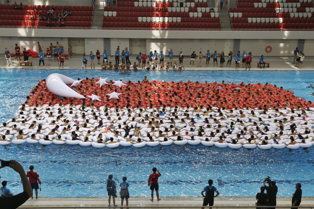 Students from primary, secondary and post-secondary schools attempt to form the largest floating Singapore flag in 2015. The Singaporean school curriculum includes extracurricular programmes to enhance students’ all-round development. Photo: The Straits Times