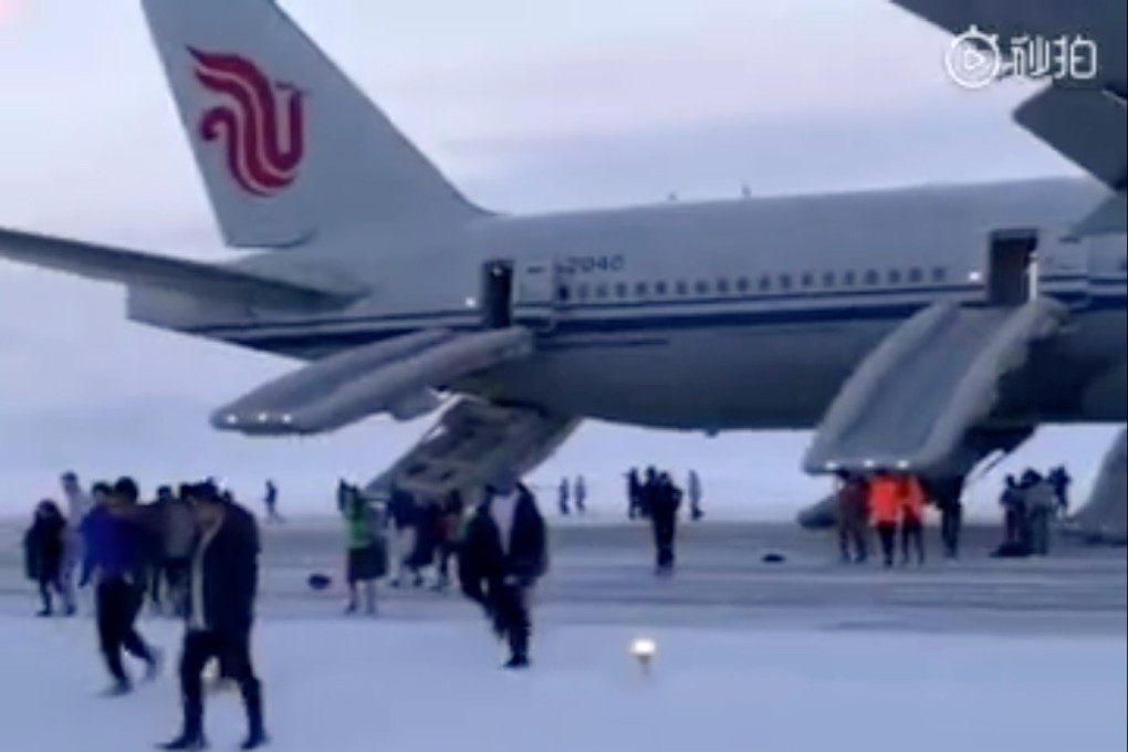 Passengers of Air China flight 983 walk through freezing temperatures, while inflatable slides wave violently in the strong winds, after an emergency landing in a remote area of subarctic Russia. Photo: Weibo