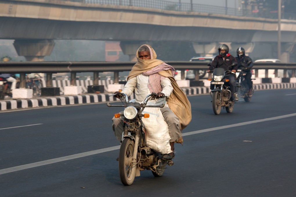 Motorists travel along a road amid heavy smog in Delhi, India. Photo: Bloomberg