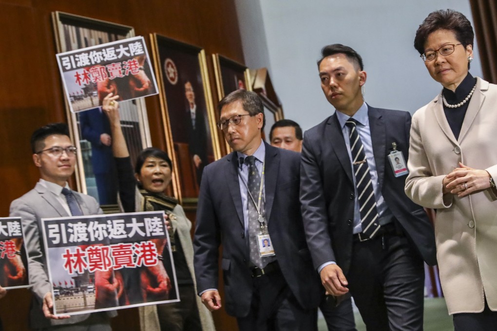 Chief Executive Carrie Lam (right) walks past pan-democrat lawmakers protesting her government’s proposal to allow case-by-case extradition arrangements between Hong Kong, the mainland, Taiwan and Macau, at the Legislative Council in Tamar, Admiralty, on February 20. Photo: K.Y. Cheng