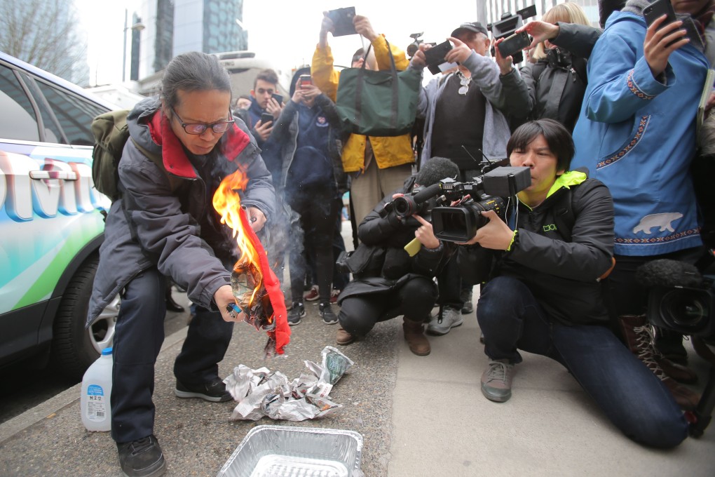 Yang Kuang burns a Chinese flag outside the British Columbia Supreme Court complex in Vancouver, where Huawei Technologies CFO Meng Wanzhou was appearing before a judge. Photo: AFP