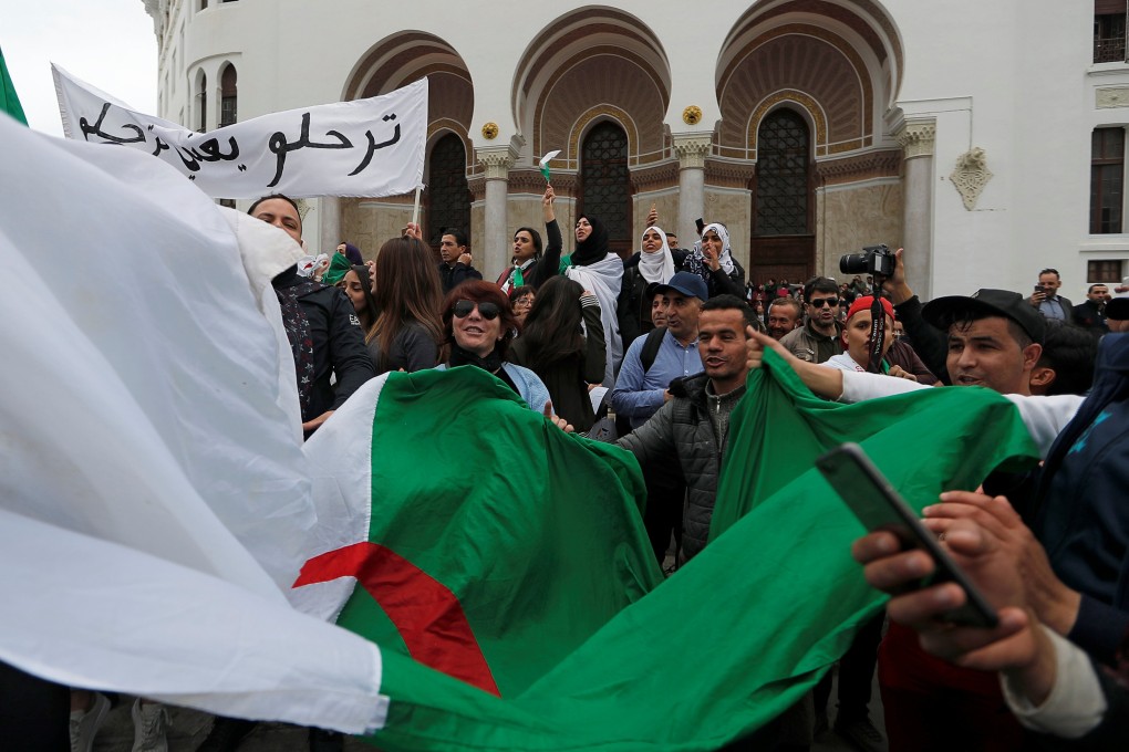 People carry a flag during a protest against Algeria’s President Abdelaziz Bouteflika, in Algiers on March 8, 2019. Photo: Reuters