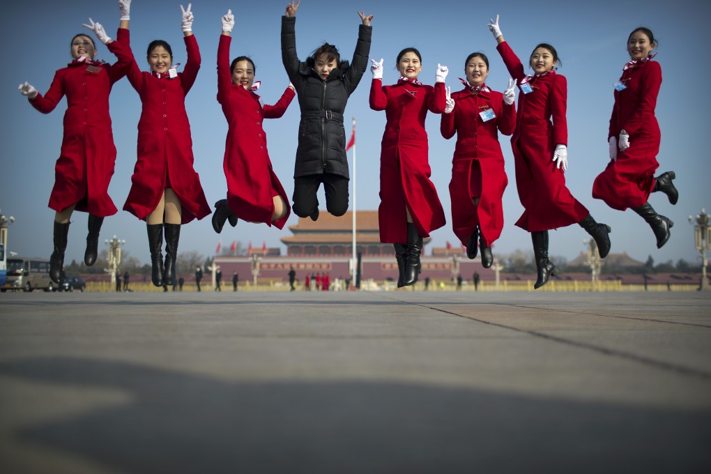 Bus ushers pose for photos ahead of the opening session of the National People’s Congress meeting at the Great Hall of the People in Beijing, on March 4. The Chinese government will step up tax cuts and increase infrastructure spending to stabilise the sagging economy, Premier Li Keqiang said in his annual work report at the meeting. Photo: AP