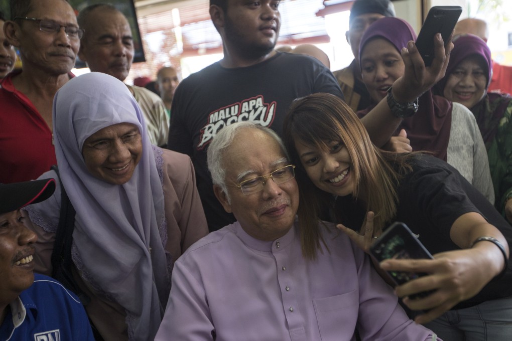 A supporter takes a selfie with former Malaysian prime minister Najib Razak, who is on bail awaiting trial on corruption charges. Photo: EPA