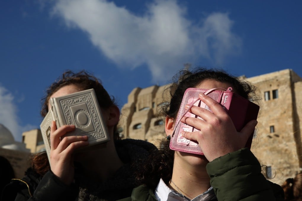 Ultra-Orthodox Jewish girls cover their faces with prayer books while protesting against the liberal Jewish movement ‘Women of the Wall’ praying at the site. Photo: AFP