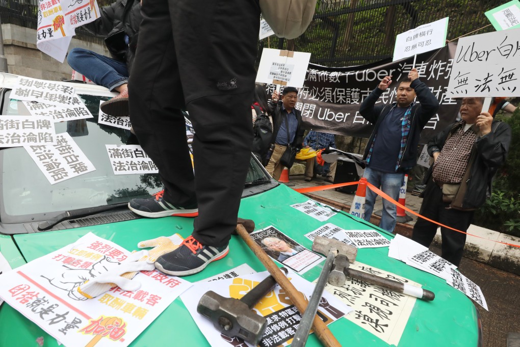 Taxi groups march and smash two cabs in a protest against illegal “white licence cars” and a proposed premium taxi scheme in January. Photo: Felix Wong