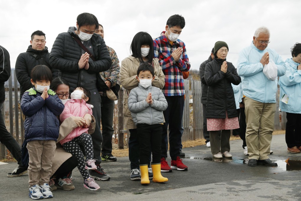 Residents of Fukushima prefecture pray at a commemorative event. Photo: Kyodo