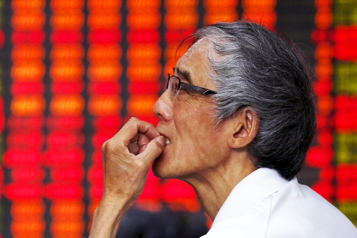 An investor looks at an electronic board showing stock information at a brokerage house in Shanghai. Photo: Reuters
