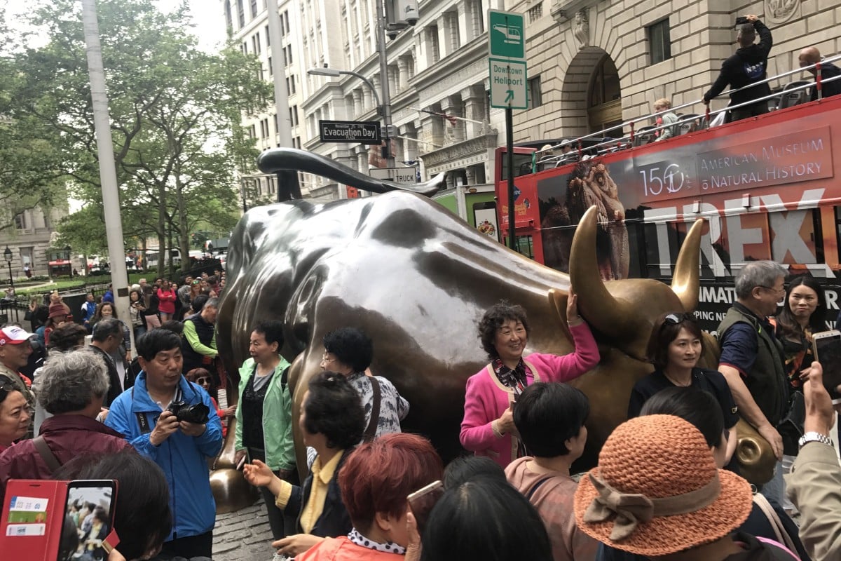 Chinese tourists check out the famous Charging Bull in New York. Photo: Yujing Liu