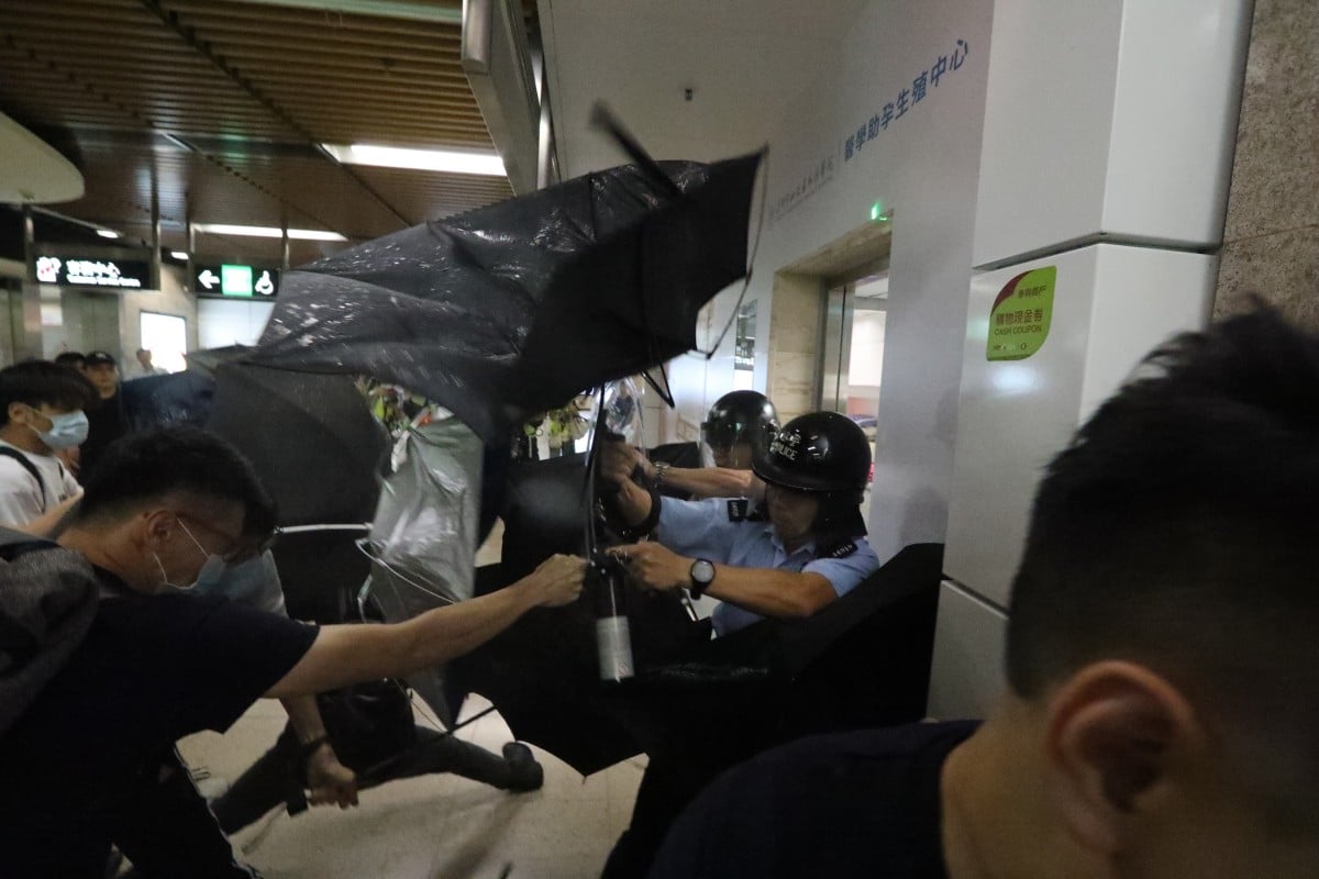 Police officers are forced to retreat into an MTR control room in Sha Tin station. Photo: Felix Wong