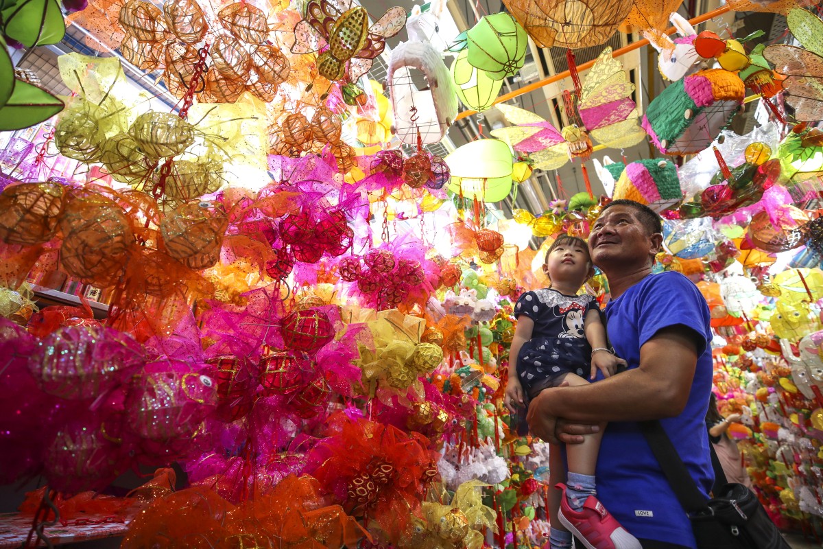 A child looks at lanterns with her father at the Tai Kiu Market in Yuen Long as part of the upcoming Mid Autumn Festival. Photo: Winson Wong