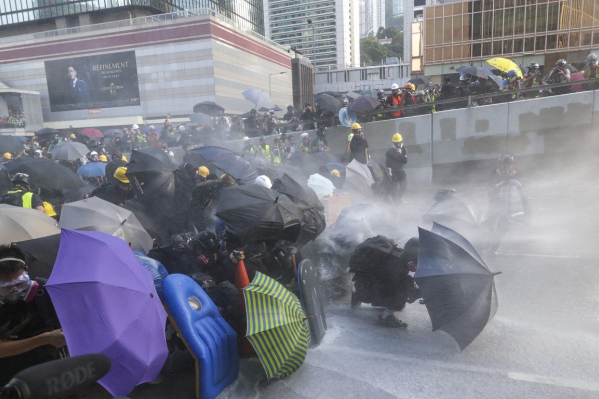 Riot police fire water at protesters from a water cannon truck on Sunday. Photo: Edmond So