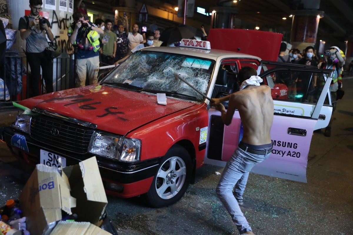 A protester in Causeway Bay smashes up an abandoned taxi. Photo: Sam Tsang