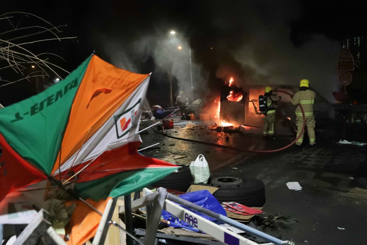 Firefighters battle a blaze at Chinese University but the protesters who have dug in for four days have left. Photo: Edmond So