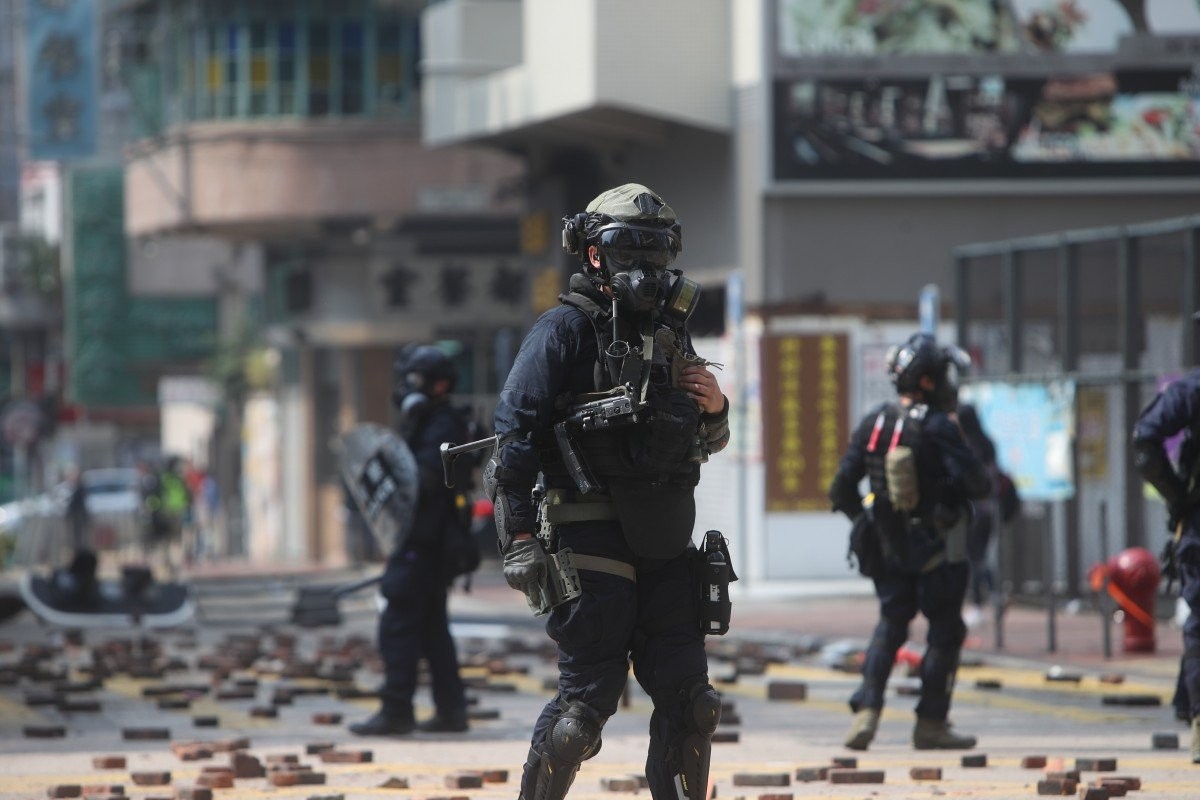 A police officer with a submachine gun is seen in a clash with protesters on Nathan Road in Tsim Sha Tsui. The escalating violence is weighing on the Hang Seng. Photo: Winson Wong