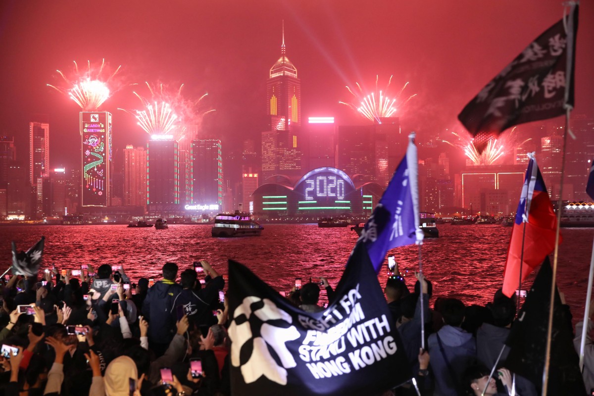 People watch the "Symphony of Lights" show in Hong Kong as part of New Year's celebrations. Photo: Winson Wong
