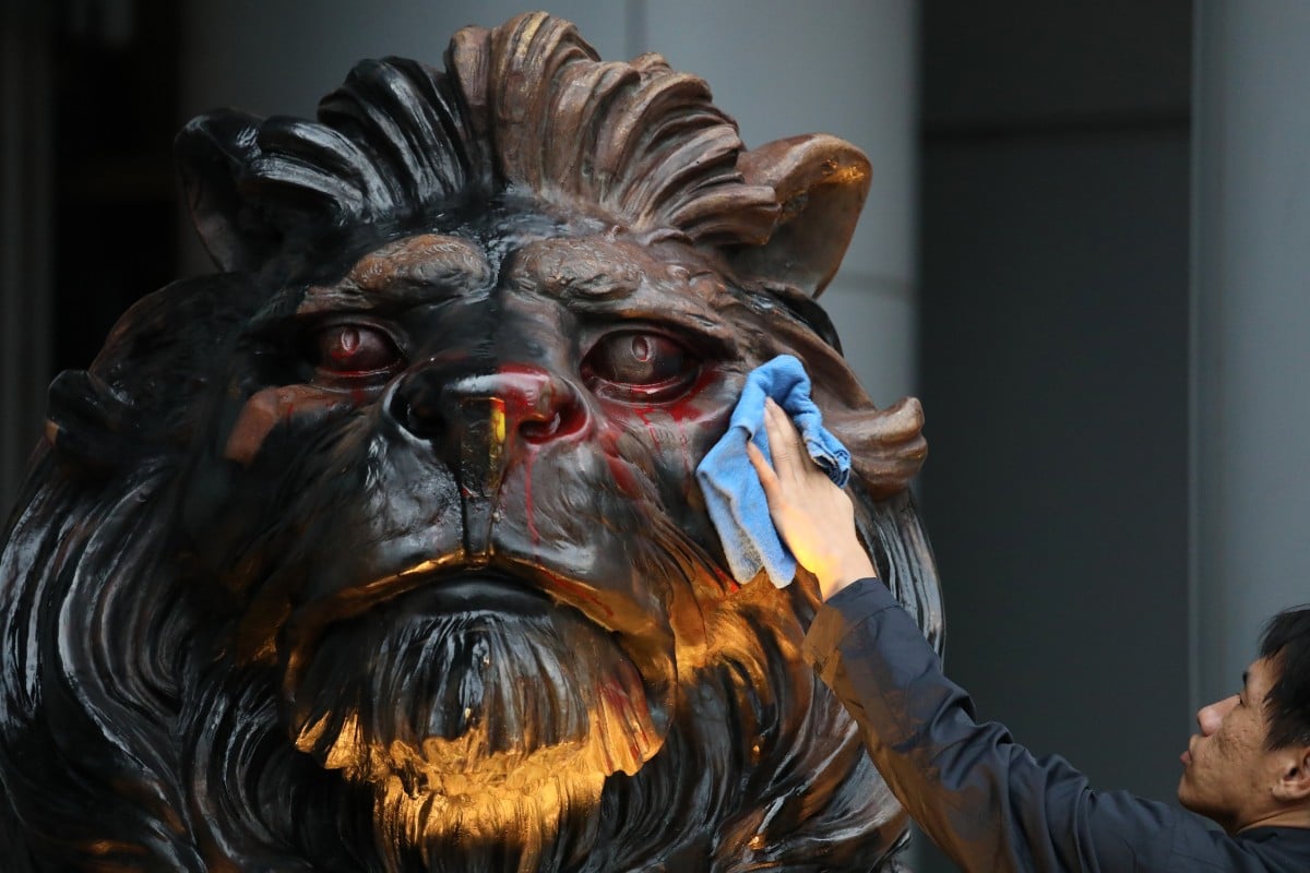 A worker on Tuesday cleans one of the lions at the HSBC headquarters in Central that was vandalised during the anti-government march on New Year's Day. Photo: Nora Tamoto 