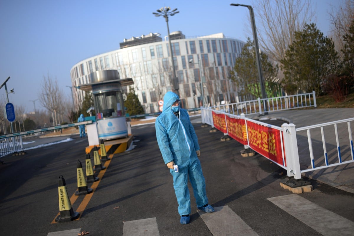 A security guard wears a protective suit and face mask as he holds a thermometer at the China Transinfo Technology Co., on the morning after the extended Lunar New Year holiday caused by the novel coronavirus outbreak in Beijing on February 10. Photo: Reuters