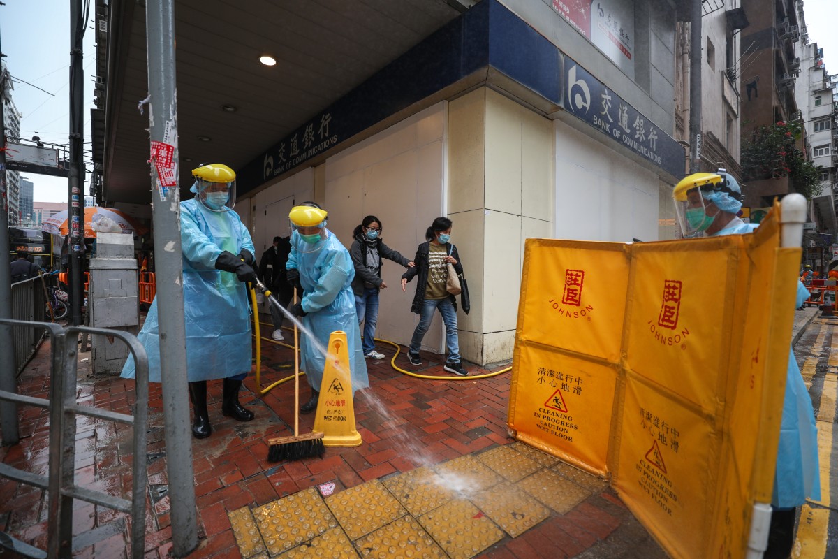 Workers wearing protective gear clean at Shu Kuk street and King's road outside Maylun Apartment where Fook Wai Ching She Buddhist worship hall is located in Hong Kong. More people who have been at Fook Wai Ching She temple in North Point have tested positive for coronavirus. Photo: Xiaomei Chen
