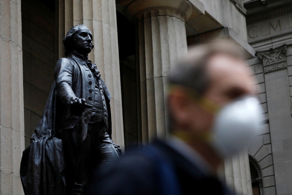 A man walks by a statue of first U.S. President George Washington in New York City on March 12, 2020. Photo: Reuters