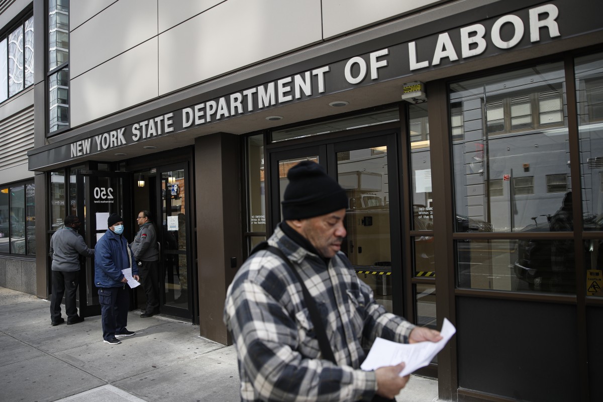 Visitors to the US Department of Labor in New York are turned away at the door by personnel due to closure over coronavirus concerns on March 18, 2020. Applications for jobless benefits are surging in some US states. Photo: Associated Press