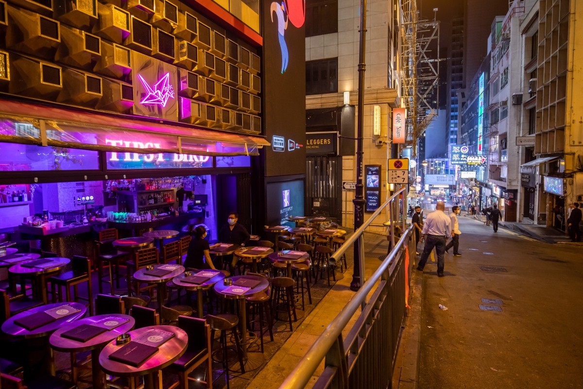 Workers stand outside a bar at night at Lan Kwai Fong inHong Kong on March 27, 2020. Hong Kong’s sprawling drinking and dining scene has been turned upside down by the virus, as the city government closed bars and imposed distance restrictions on tables in restaurants. Photo: Bloomberg
