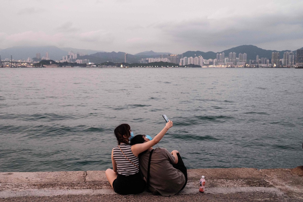 Two people take a break from the virus to take a selfie on a cargo dock in Hong Kong on April 21, 2020. Photo: AFP
