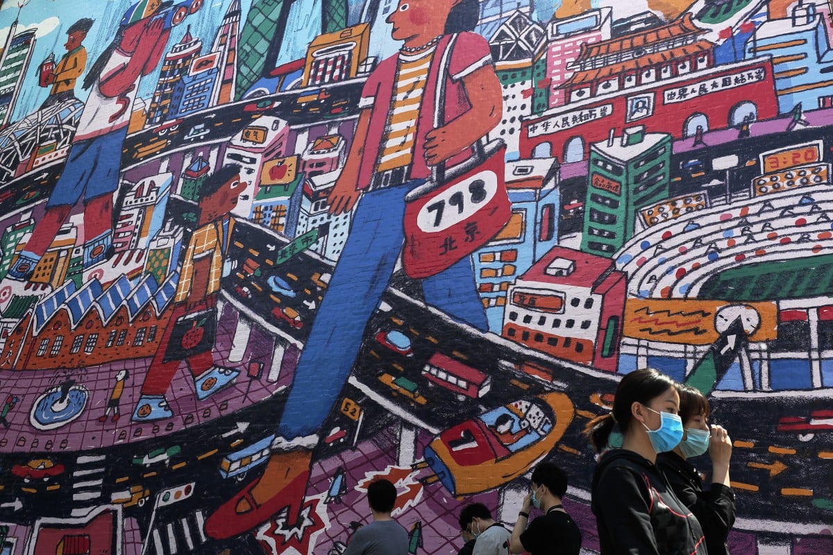 People walk by a giant painting in Beijing depicting China's capital city on April 26, 2020.  Photo: Associated Press