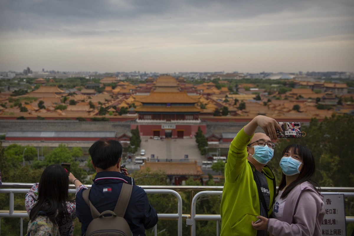 People pose for a selfie at a public park overlooking the Forbidden City, which remains closed to the public, in Beijing on April 25, 2020. Photo: Associated Press