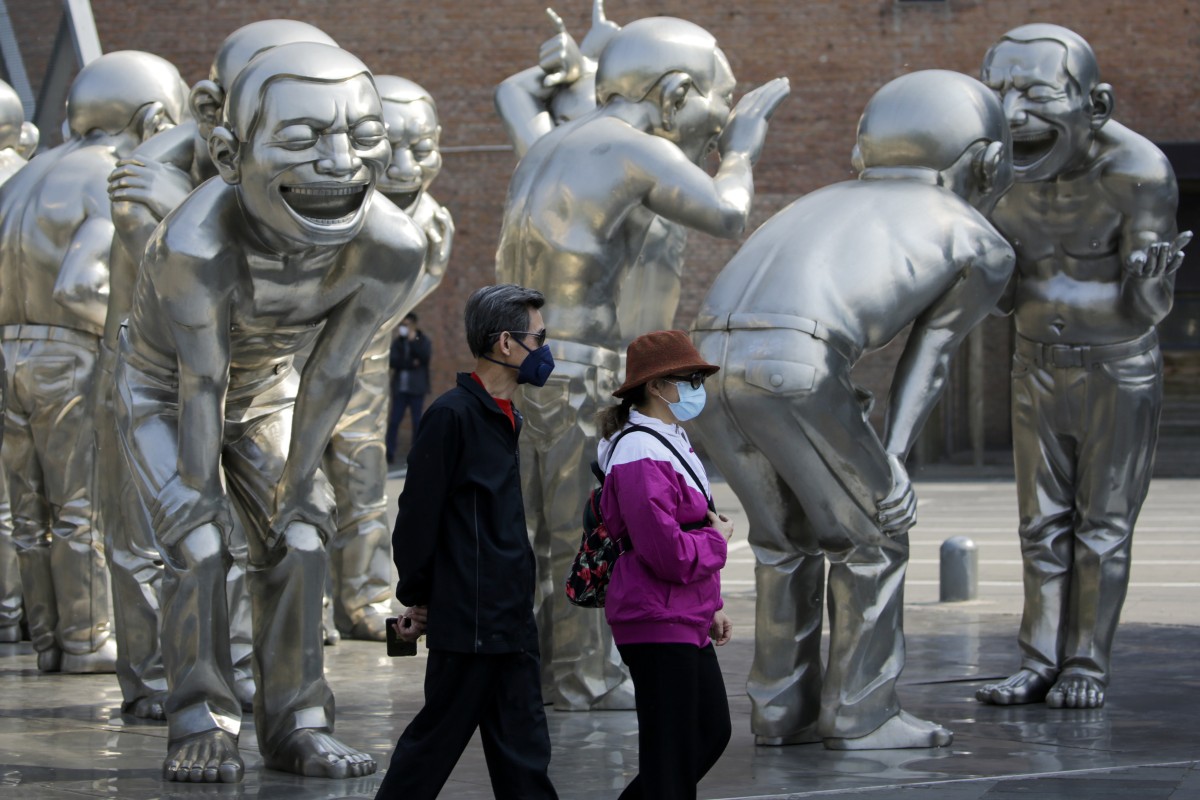 People walk by sculptures on display outside an art gallery in Beijing on April 28, 2020. Photo: Associated Press

