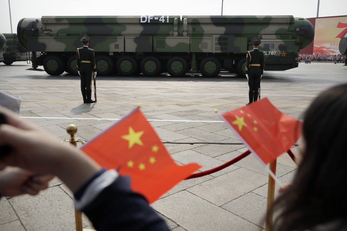 Spectators wave Chinese flags as military vehicles carrying DF-41 ballistic missiles roll during a parade on October 1, 2019, to commemorate the 70th anniversary of the founding of Communist China in Beijing. Photo: AP