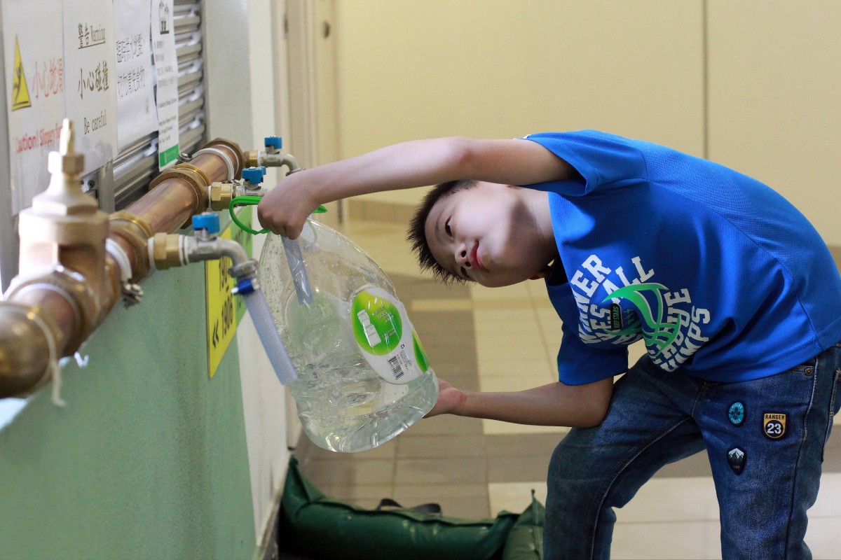 A boy fetches water from newly installed temporary pipes at Kai Ching Estate in August 2015 after investigations revealed excessive levels of lead in the piped water. Photo: May Tse