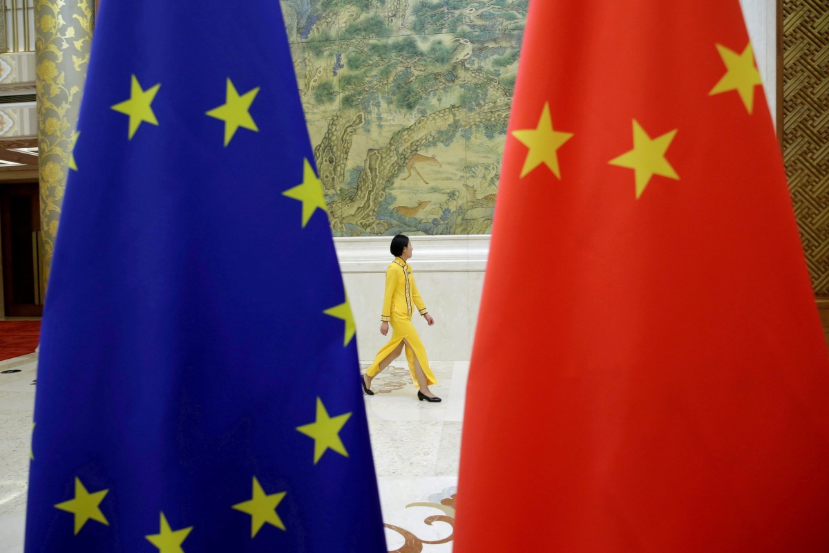 An attendant walks past EU and China flags ahead of the EU-China High-level Economic Dialogue at Diaoyutai State Guesthouse in Beijing, China June 25, 2018. Photo: Reuters 